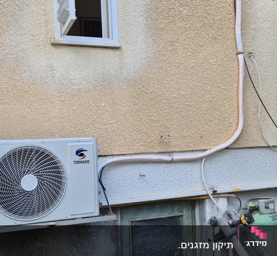 יחידת מזגן חיצונית מותקנת על קיר בניין
